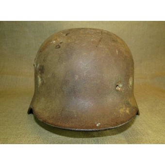 ET 64 marked M 35 war time reissued camouflaged steel helmet with fragmentation damage. Espenlaub militaria
